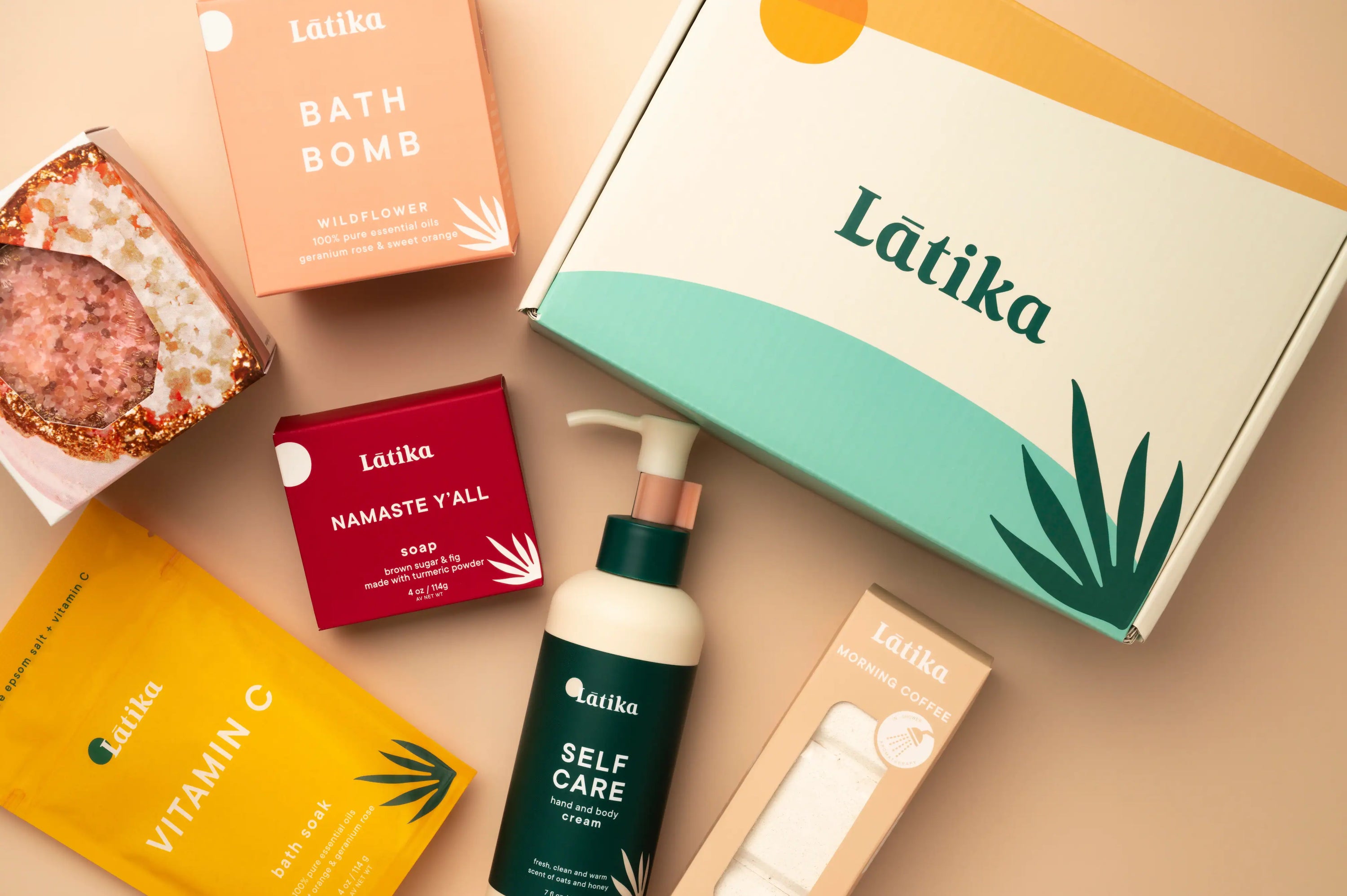 Collection of Látika self-care products including bath bombs, soap, and skincare items on a beige background.