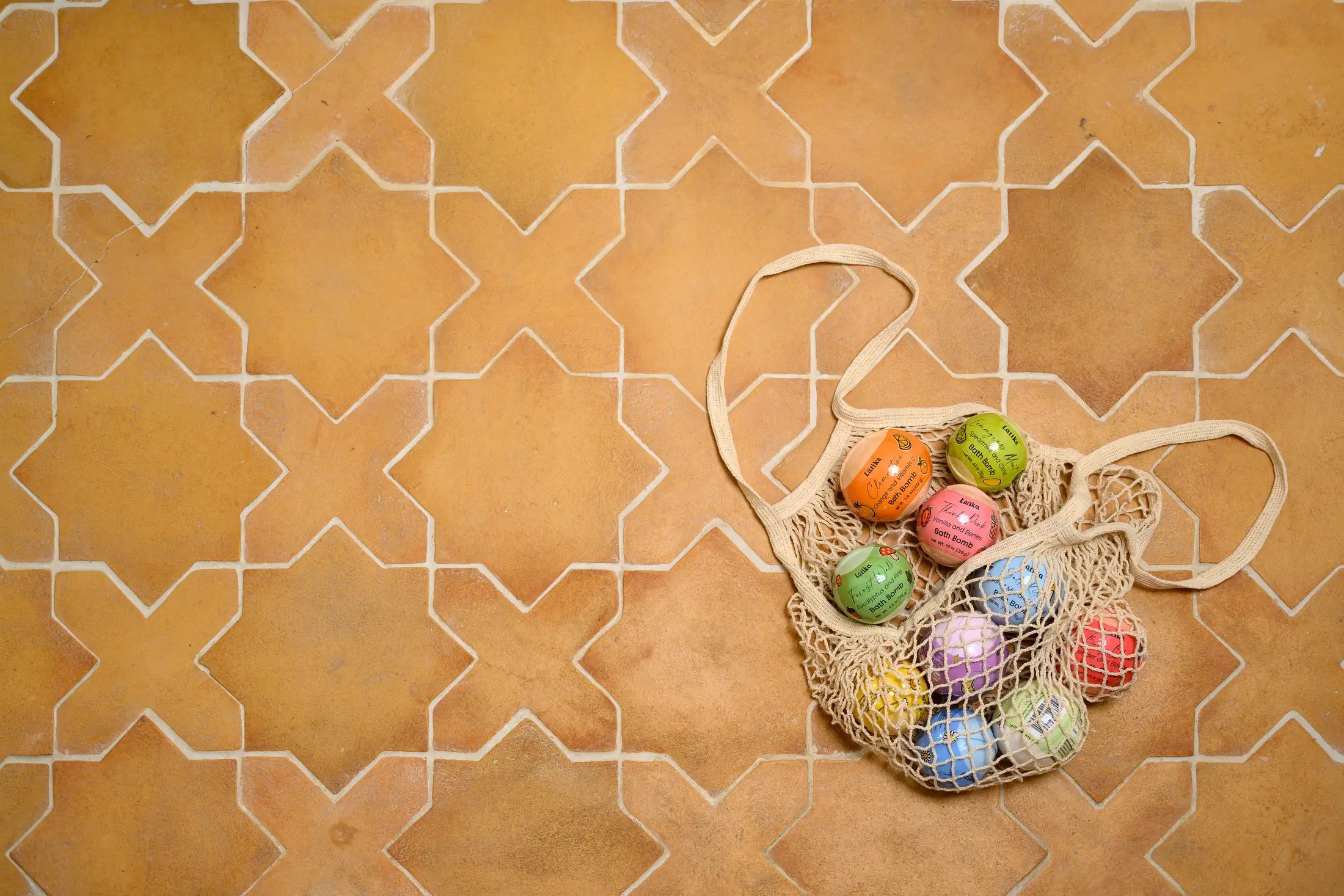Net bag with colorful eggs on a patterned tile floor