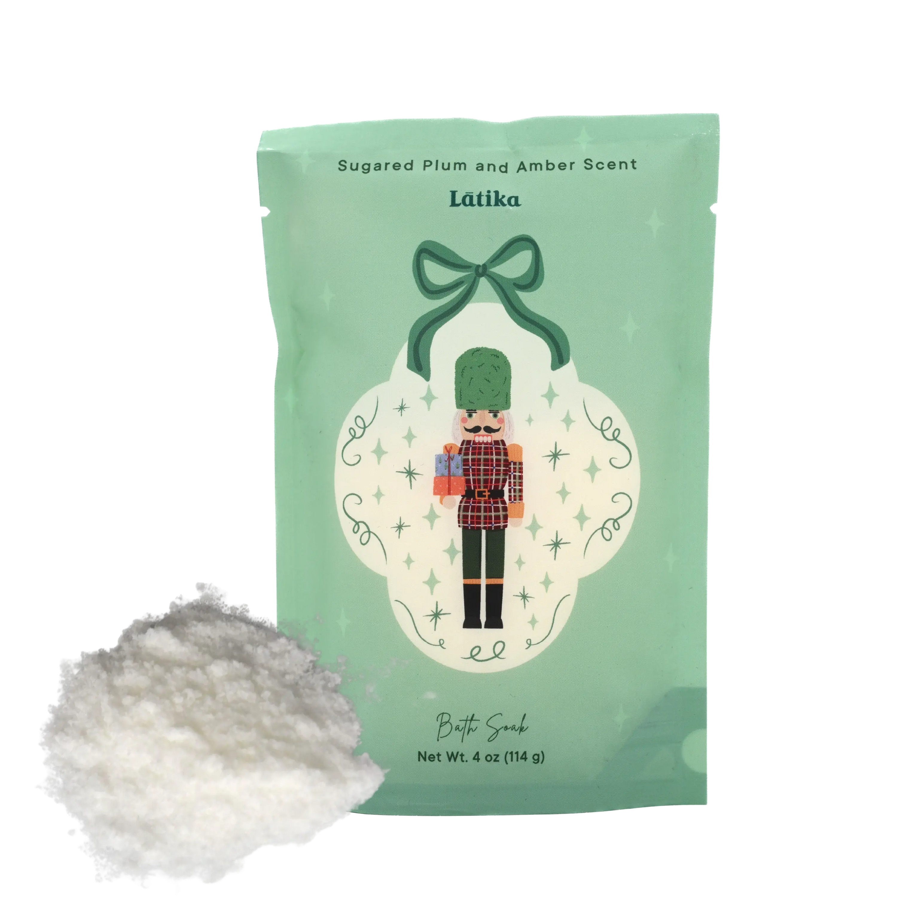Mint green packaging of a product with a Nutcracker design, accompanied by a small pile of bath powder. for an elegant holiday gift.