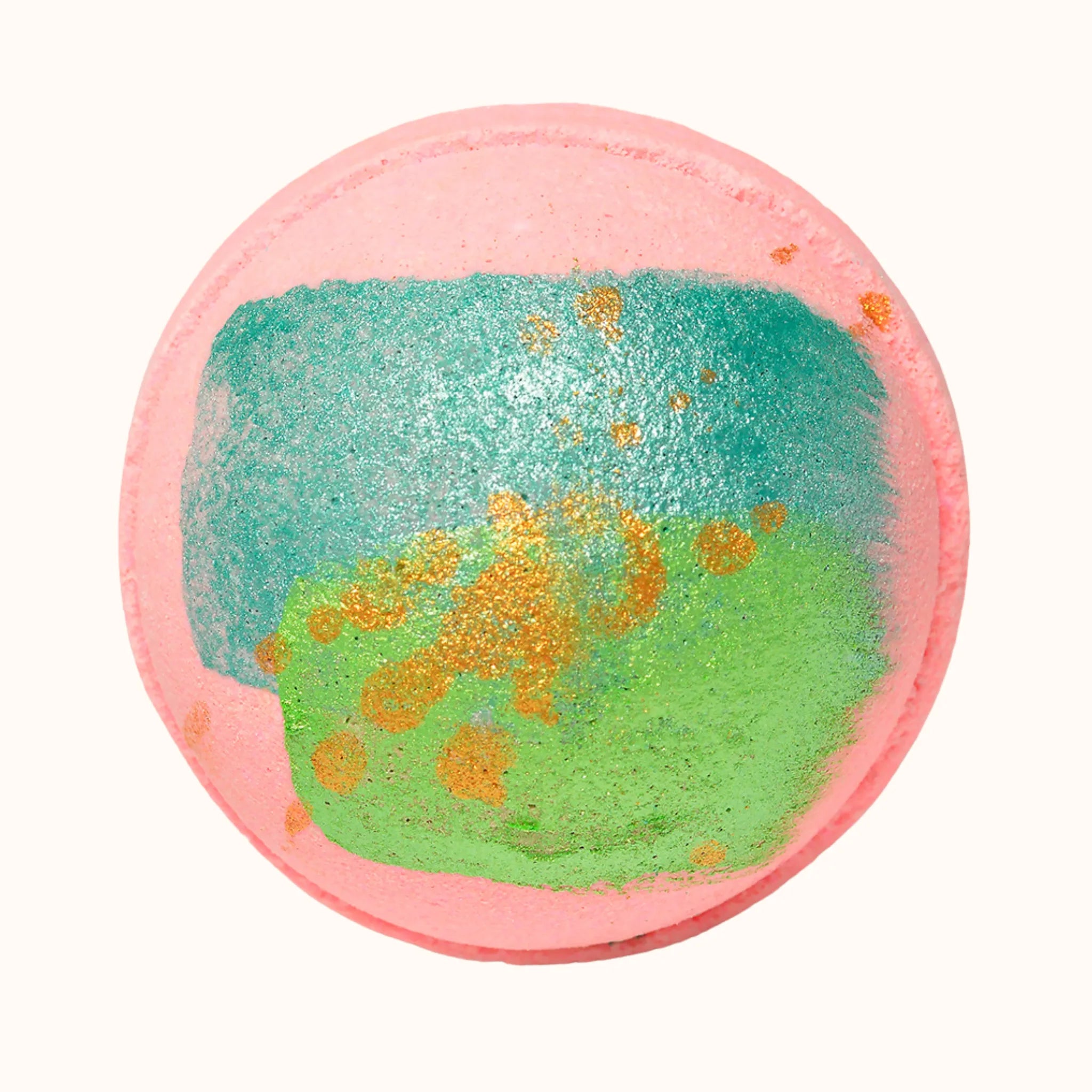 Round bath bomb with pink outer layer, green and gold center. for a fun pink bath