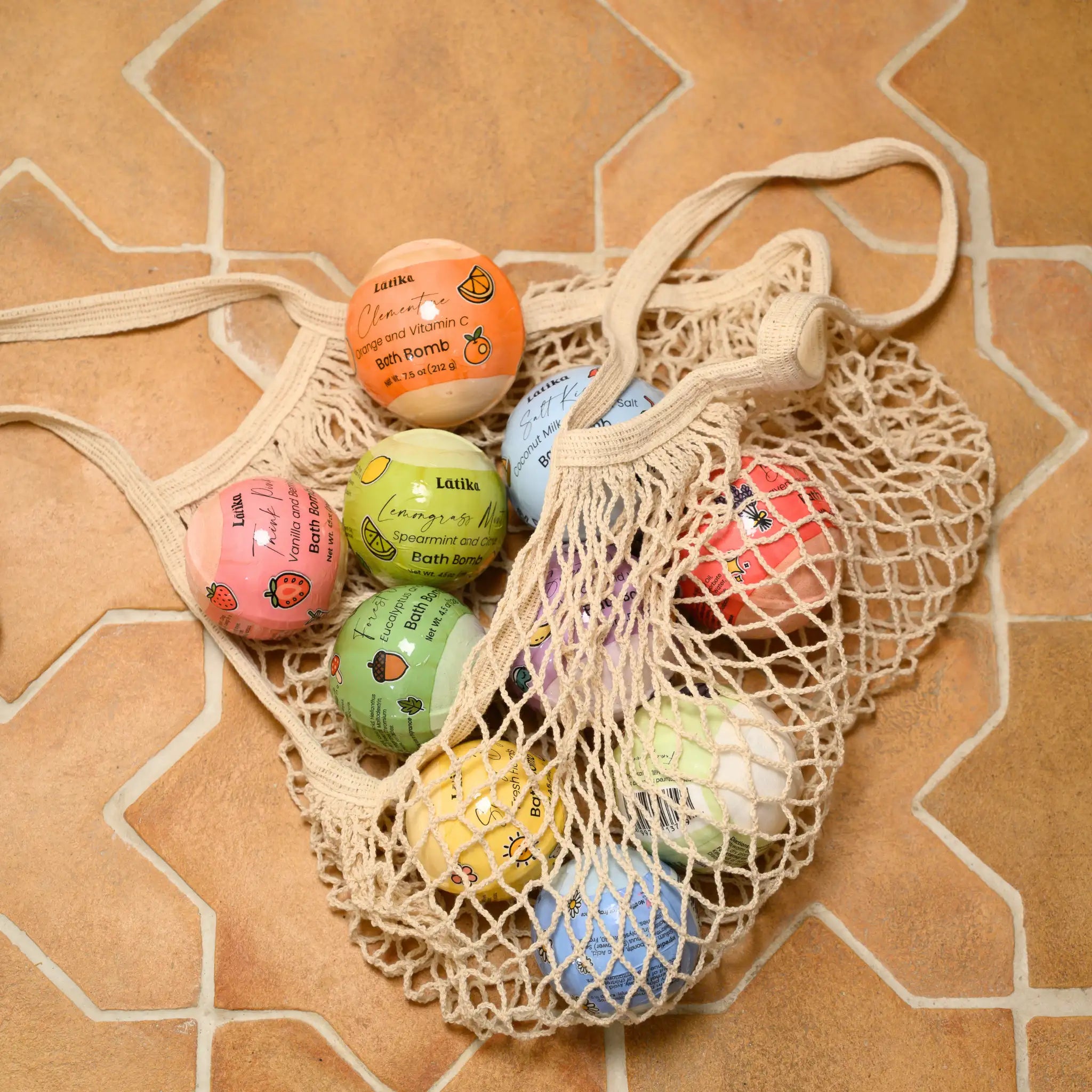 Mesh bag filled with colorful bath bombs on a patterned surface