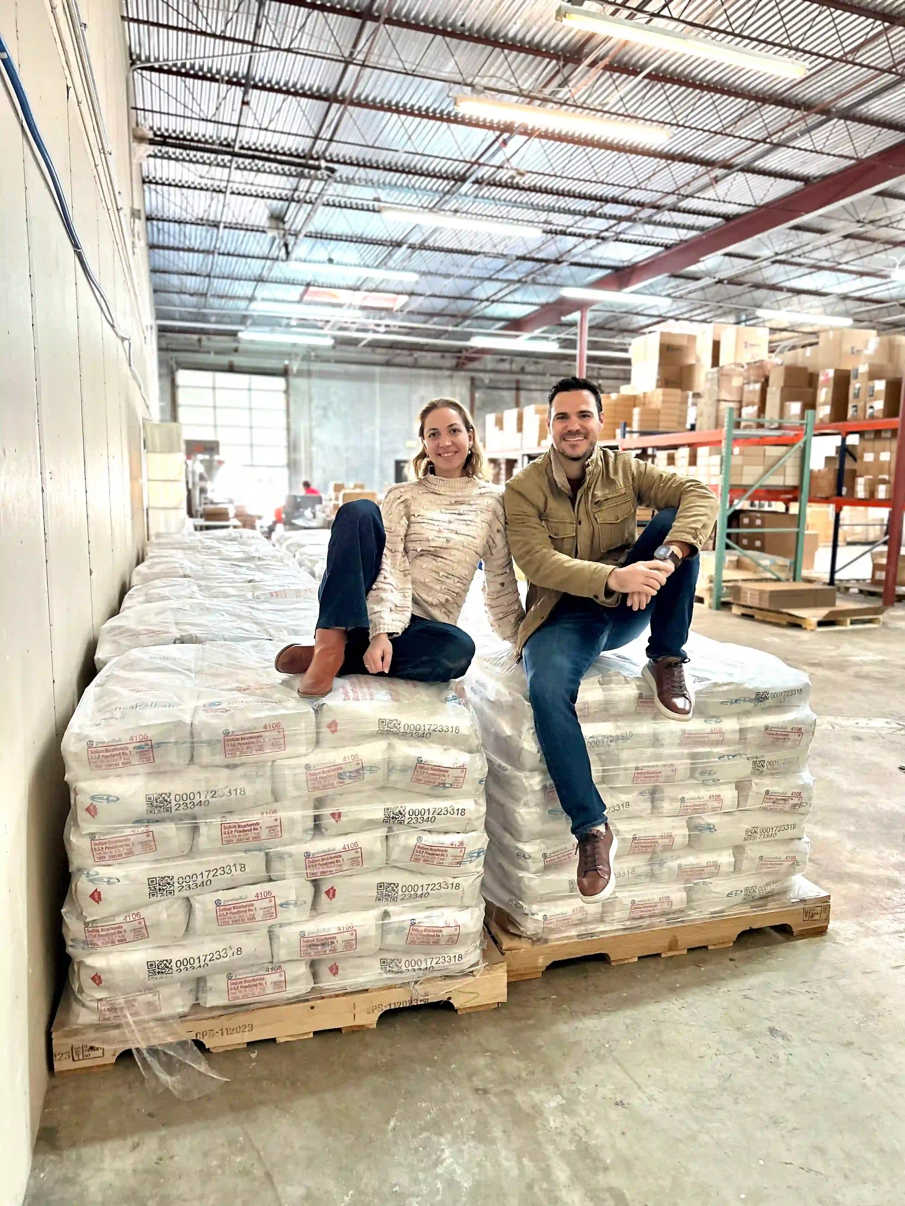 Founders standing with pallets of raw magnesium chloride sourced from the Dead Sea