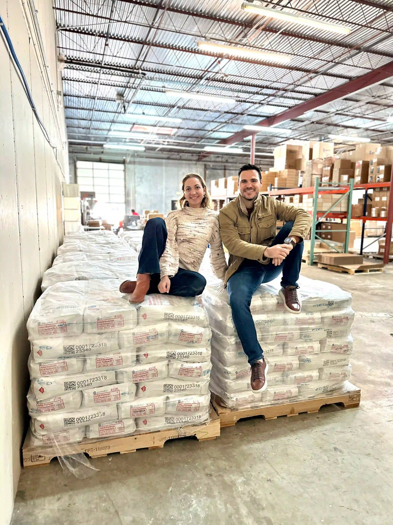 Founders standing with pallets of raw magnesium chloride sourced from the Dead Sea