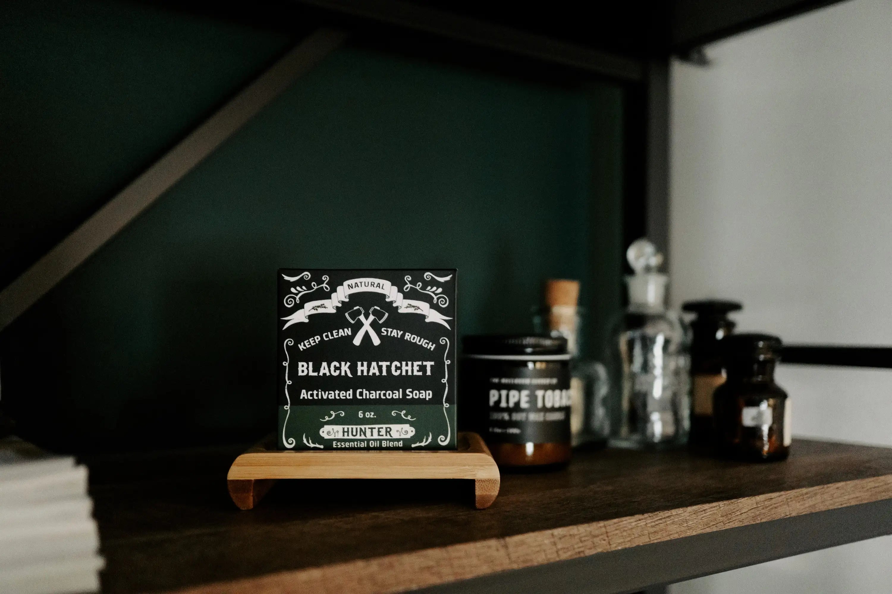 Product display with 'Black Hatchet' sign on a wooden shelf. and a men's soap bar on it.