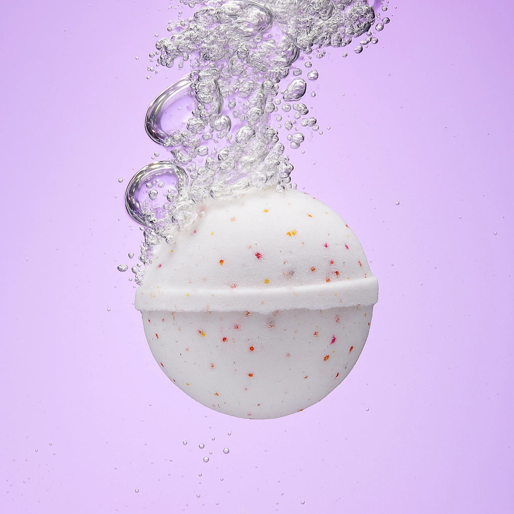 white bath bomb with sprinkles submrged in water