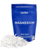 Blue package of Latika magnesium bath soak with white magnesium flakes on a white background