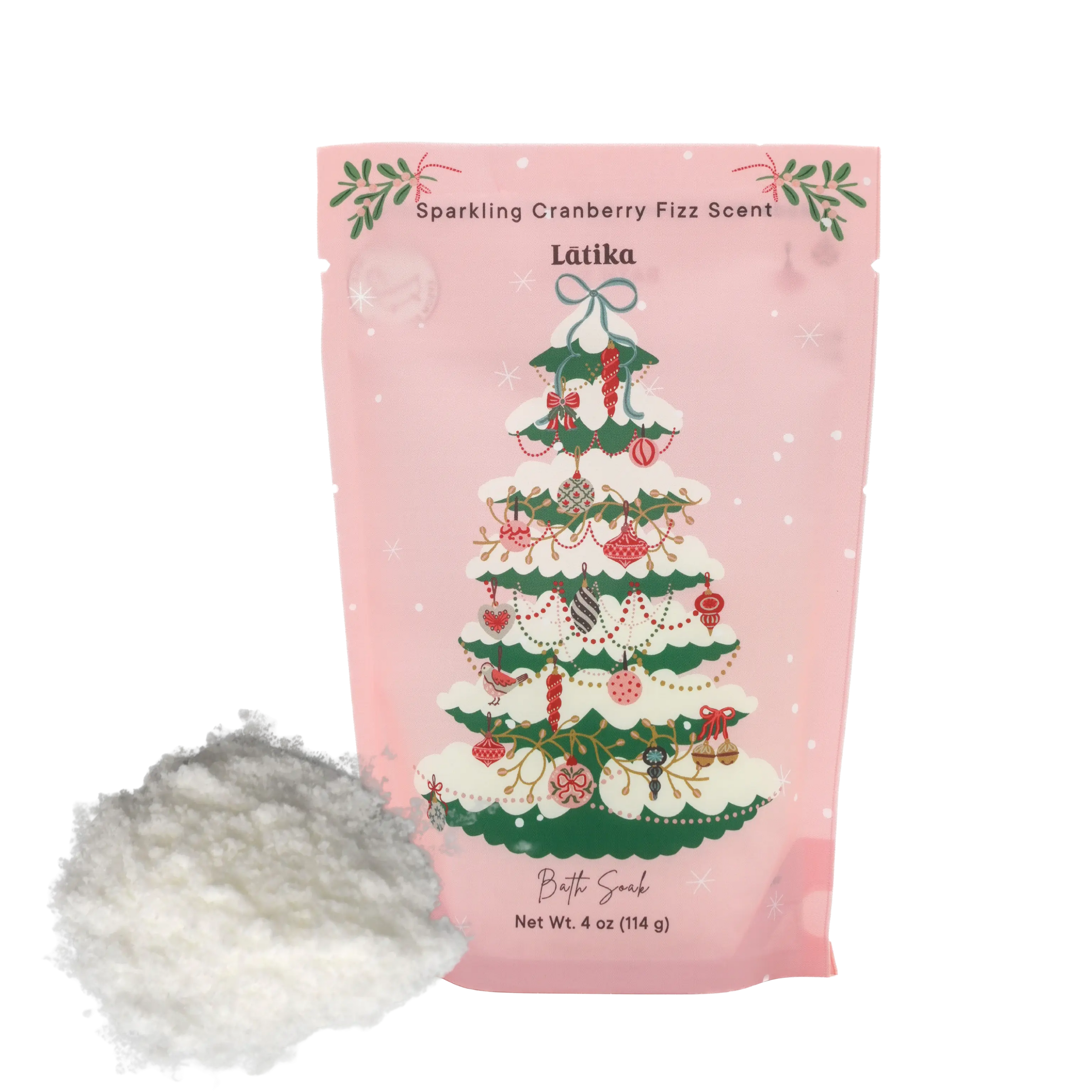 Pink packaging with a Christmas tree design, accompanied by a pile of pink bath salts on a white background.