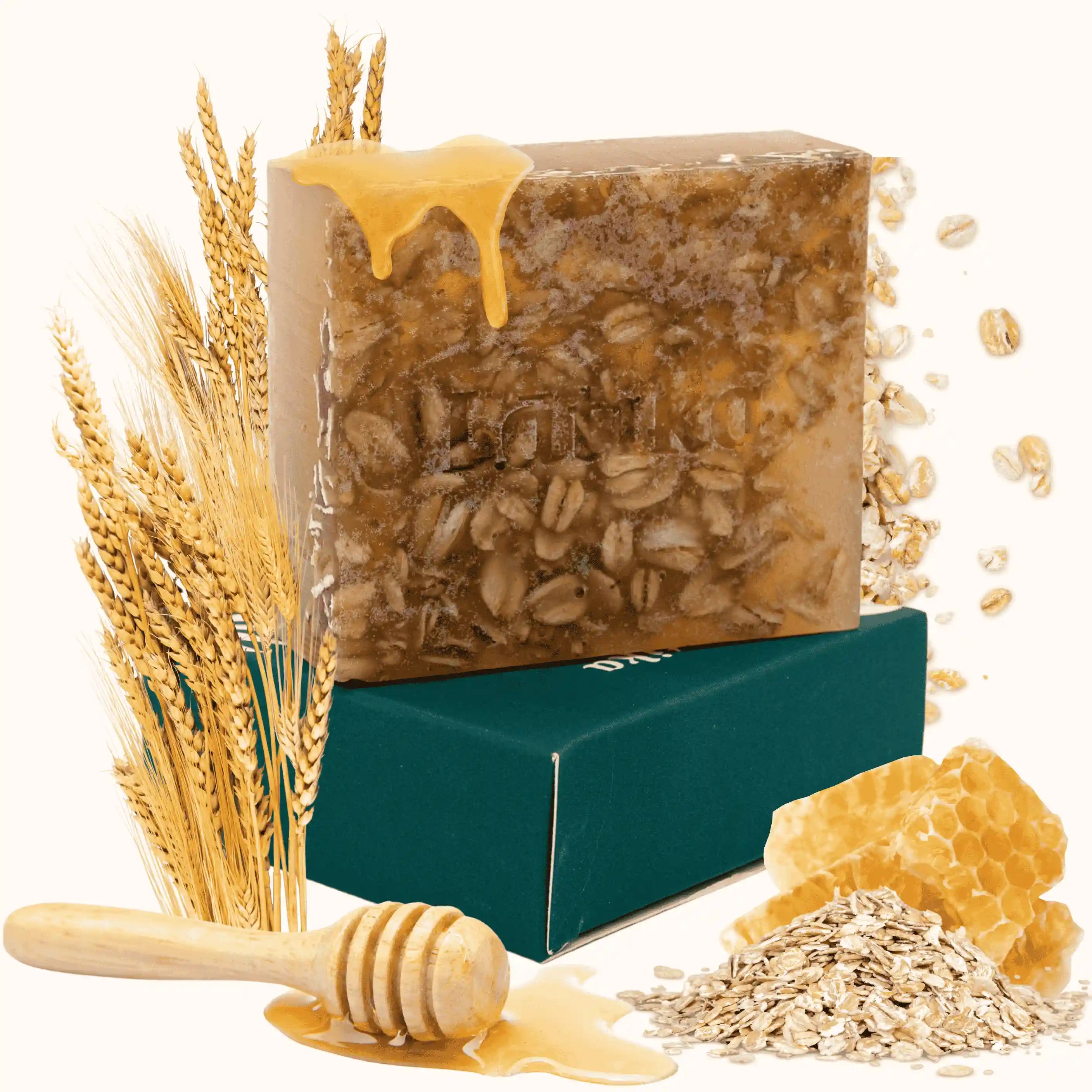 Bar of soap with honey and oats, surrounded by wheat stalks and honeycomb on a white background
