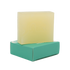Yellow bar of soap on a green soap dish against a white background
