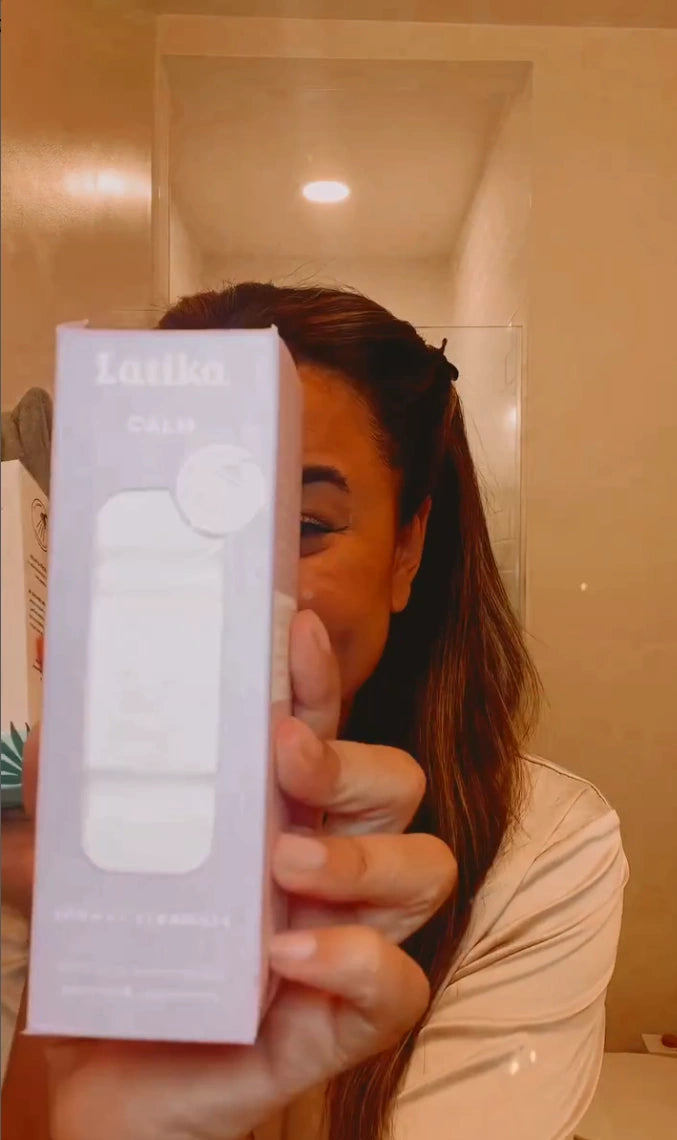 Person holding a white electronic device in a bathroom.