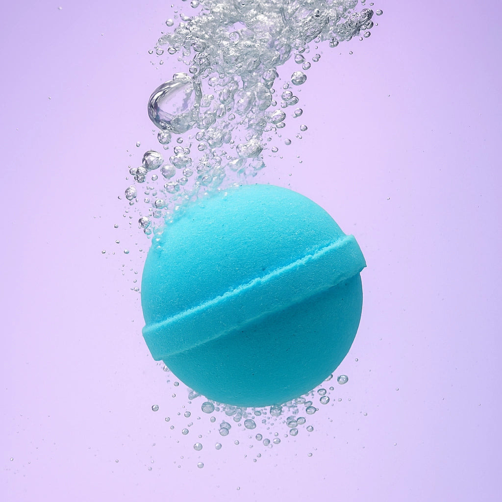 blue bath bomb with sweet candy scent, submerged in water with bubbles